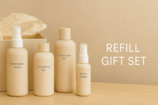 Wide thumbnail showing a minimalist refill gift set with room spray, diffuser oil, conditioner, and a refillable bottle arranged in neutral beige tones on a wooden surface.